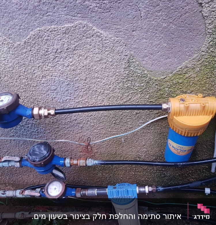 מד מים, צינורות ומסנן מים על קיר